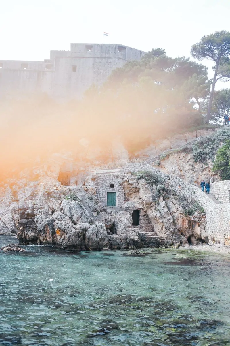 Private boat on the Adriatic sea near Dubrovnik city walls at sunset